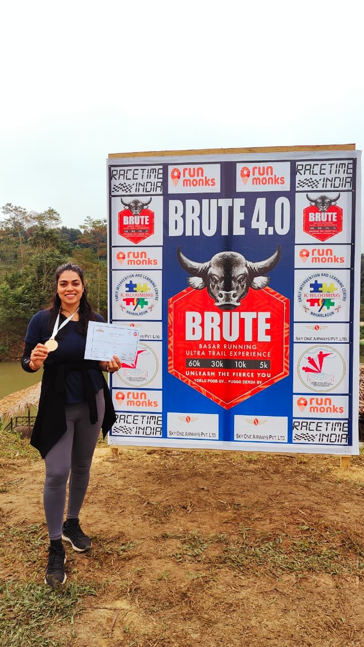 Holding a finisher medal at the Brute 4.0 race