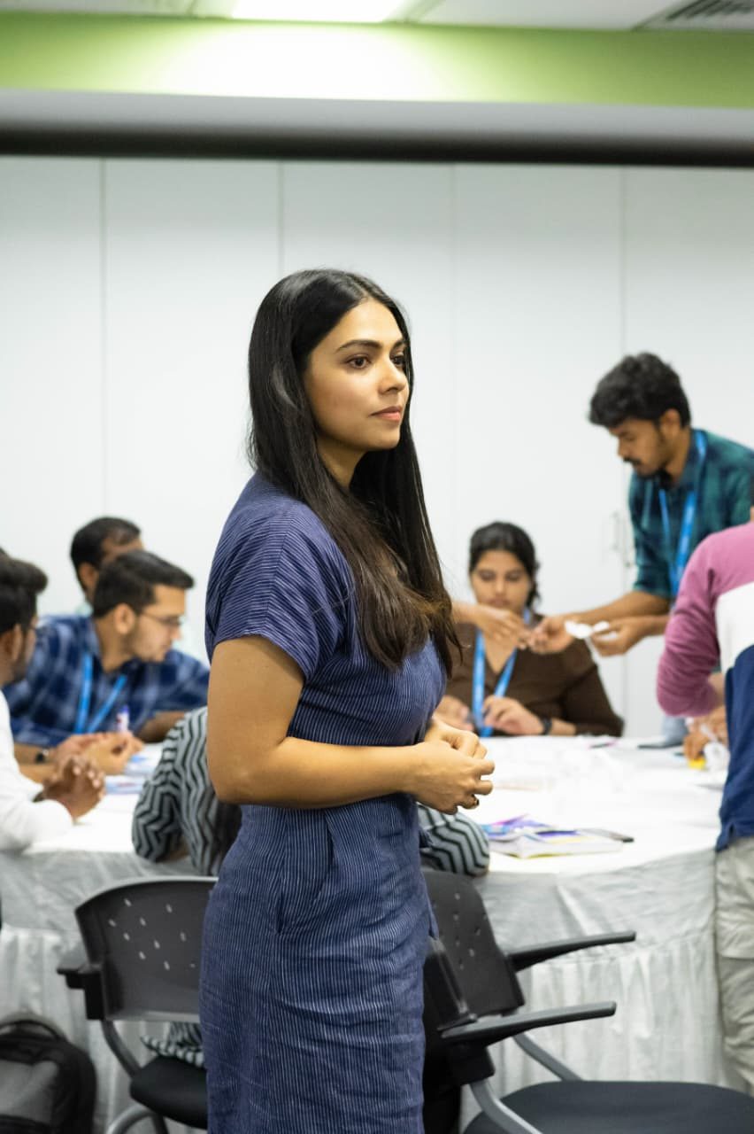 Standing among participants at a workshop table